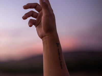 Close up of hands reaching for the sky.